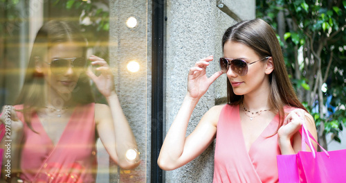 Beautiful young woman checking a store outdoor in a modern city setting