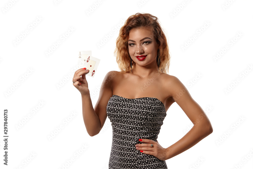 Ginger girl wearing gray dress is posing holding two playing cards in her hands standing isolated on white background. Casino, poker. Close-up shot. Ginger girl wearing gray dress is posing holding two playing cards in her hands standing isolated on white background. Casino, poker. Close-up shot.