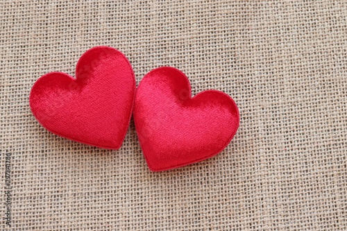 two red hearts symbol of love on sackcloth