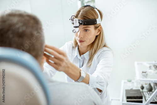Valokuva Portrait of a female confident otolaryngologist during a medical examination of