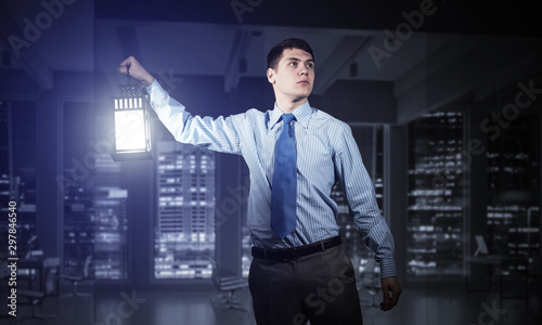 Scared businessman holding glowing lantern