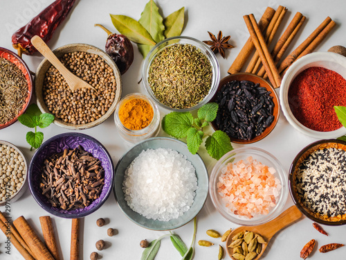 Fototapeta Naklejka Na Ścianę i Meble -  An assortment of different dry spices in small bowls on a white background. Top view.