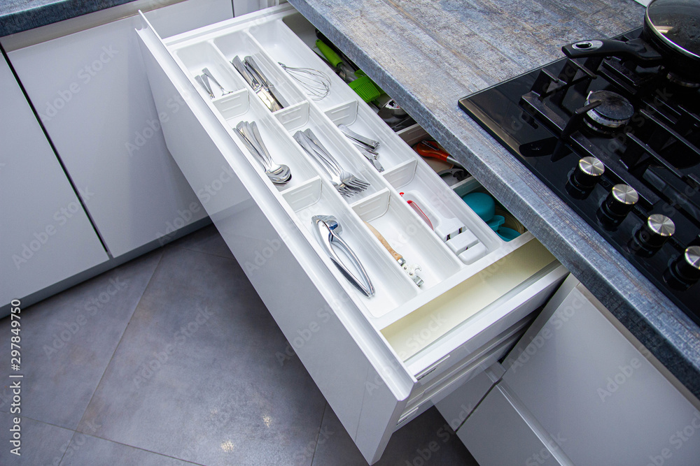 Φωτογραφία Kitchen appliances forks, spoons, knives in a drawer of built-in furniture in the kitchen