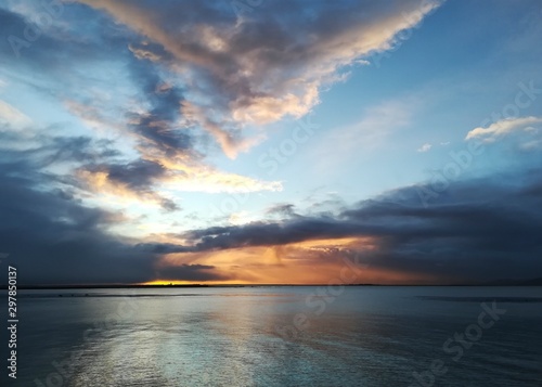 Stunningly beautiful sunrise, taken on a cloudy morning from Salthill beach near Galway, Ireland. Showing the calm water of Galway Bay and Mutton Island in the distance.