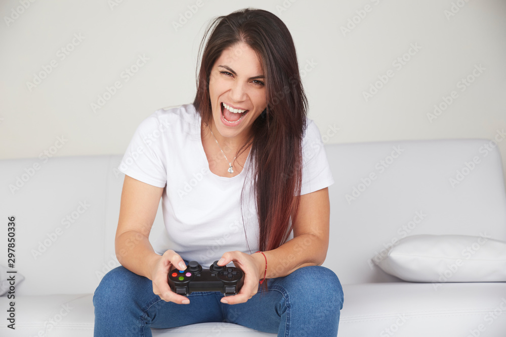 pretty woman play videogames on sofa - obrazy, fototapety, plakaty 