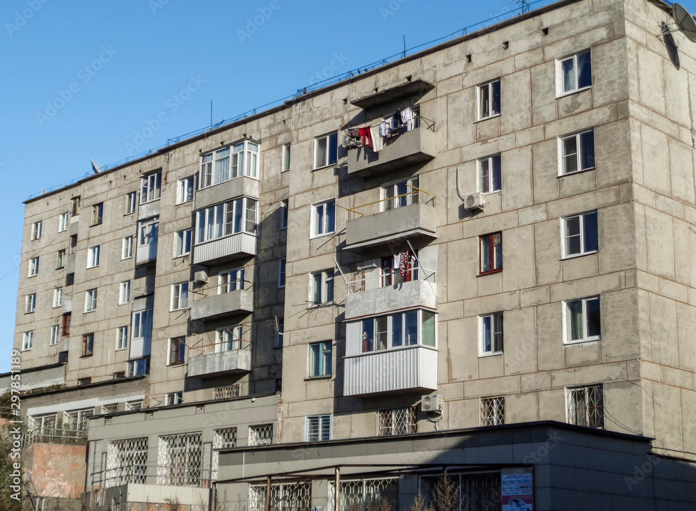 Soviet architecture. Ust-Kamenogorsk (Kazakhstan). Apartment building. Soviet architectural style. Typical socialist apartment building. Apartment block. Blue sky