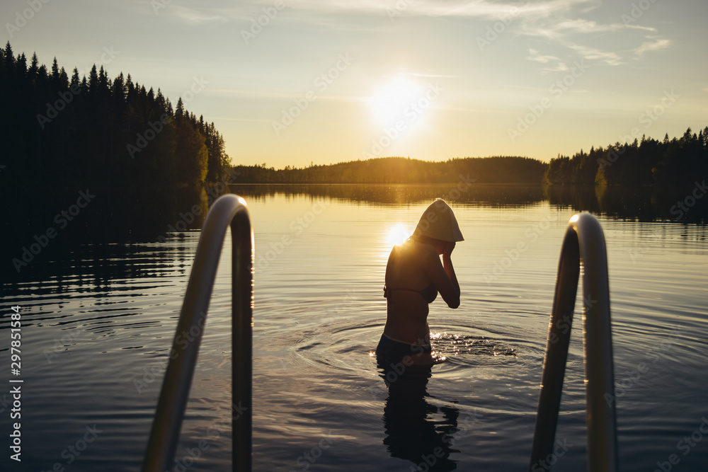 Young woman swimming in the lake at sunset after sauna in Finland Stock  Photo | Adobe Stock