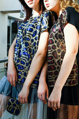 two girls in blue and red leopard dresses
