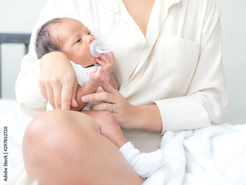 A beautiful Asian woman puts her newborn baby on her body happily and with love A beautiful Asian woman puts her newborn baby on her body happily and with love