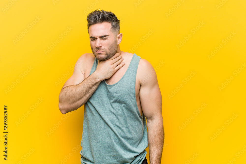 Young fitness man against a yellow background suffers pain in throat due a virus or infection. Young fitness man against a yellow background suffers pain in throat due a virus or infection.