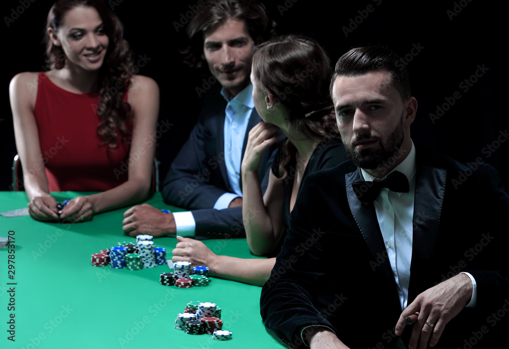 Man with cigar looking up from poker game in casino Man with cigar looking up from poker game in casino