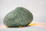 one green smooth stone on a white background