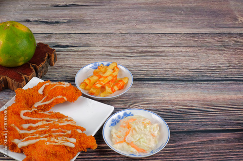 Chicken chop in white plate , coleslaw and french fries  on wood background photo