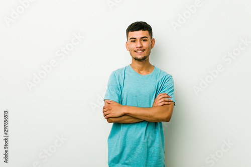 Young hispanic man who feels confident, crossing arms with determination.
