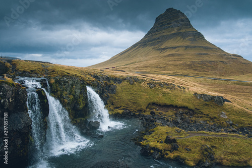 Kirkjufellsfoss waterfall and Kirkjufell mountain behind. On very cloudy and rainy day at Iceland. Beautiful landscape