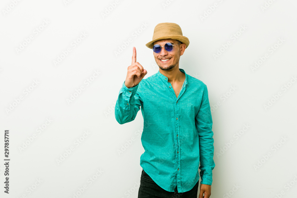 Young hispanic man wearing a summer clothes showing number one with finger. Young hispanic man wearing a summer clothes showing number one with finger.
