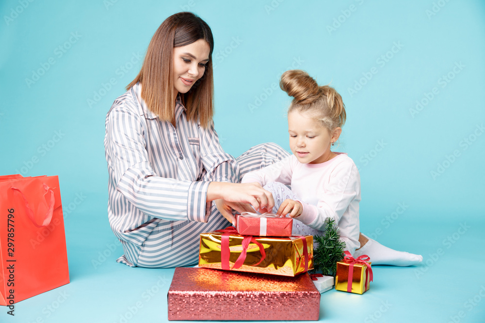Happy mother and daughter with presents. Pretty family in the New year concept Happy mother and daughter with presents. Pretty family in the New year concept