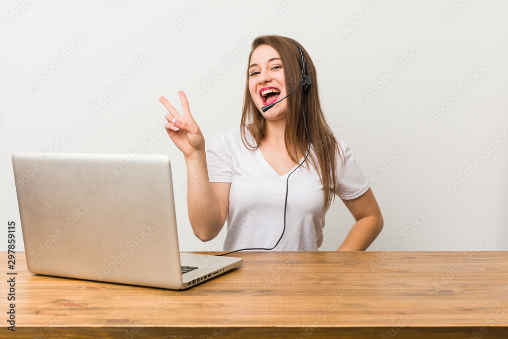 Young telemarketer woman joyful and carefree showing a peace symbol with fingers. Young telemarketer woman joyful and carefree showing a peace symbol with fingers.