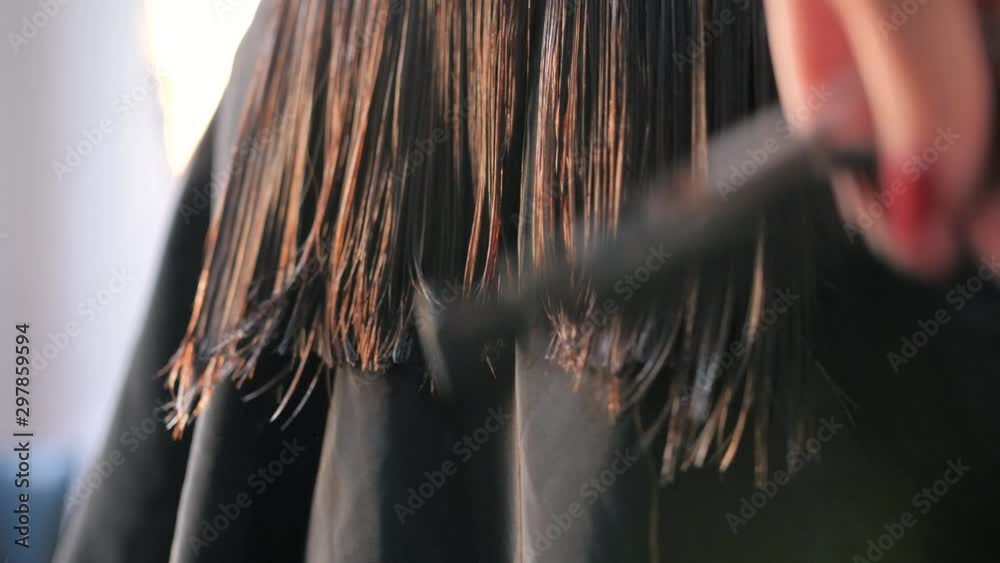 A close up of hair dresser trimming the customer's hair during hair cut session at the saloon. Concept of beauty and health. 4k,30fps.