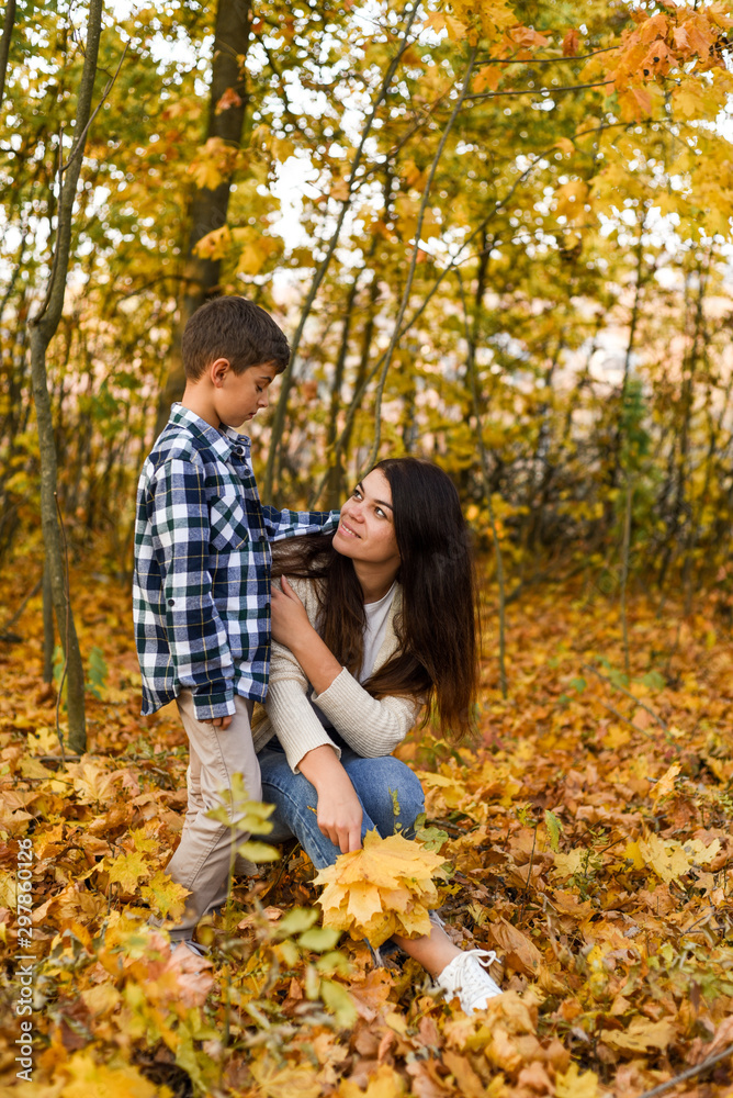 mom and son collecting leaves in autumn park. copy space mom and son collecting leaves in autumn park. copy space