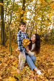 mom and son collecting leaves in autumn park. copy space