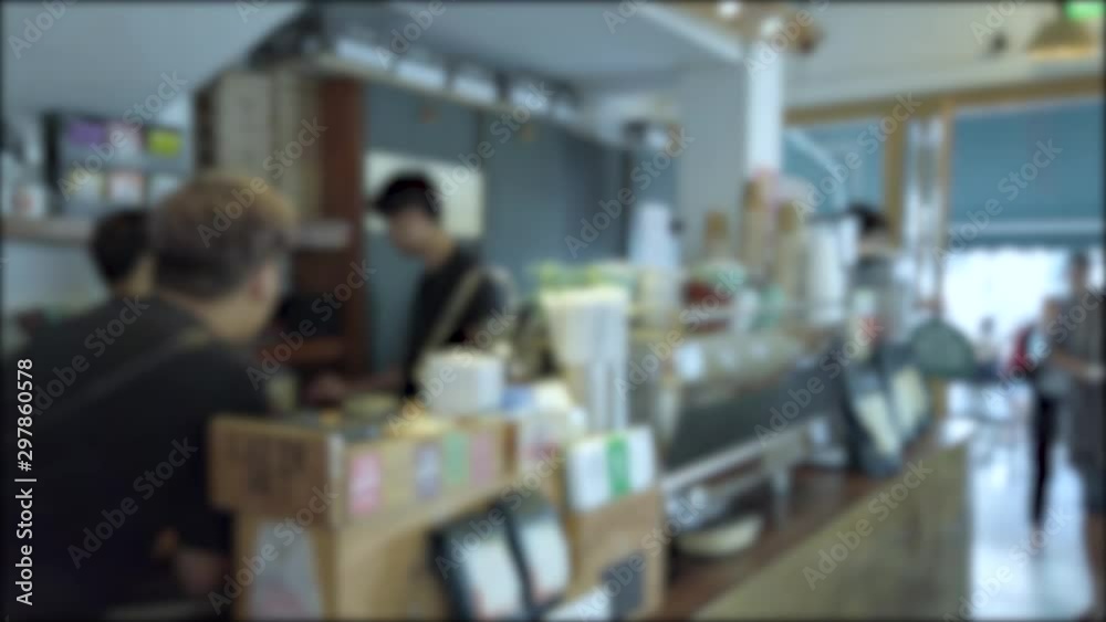 Blurred/out of focussing technique of landscape view inside the cafe with some people relaxing in cafe in summer daytime