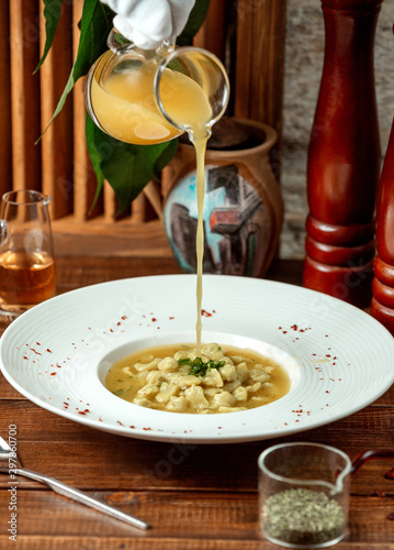 waiter pouring vinegar into azerbaijani dumplings soup dushbara photo