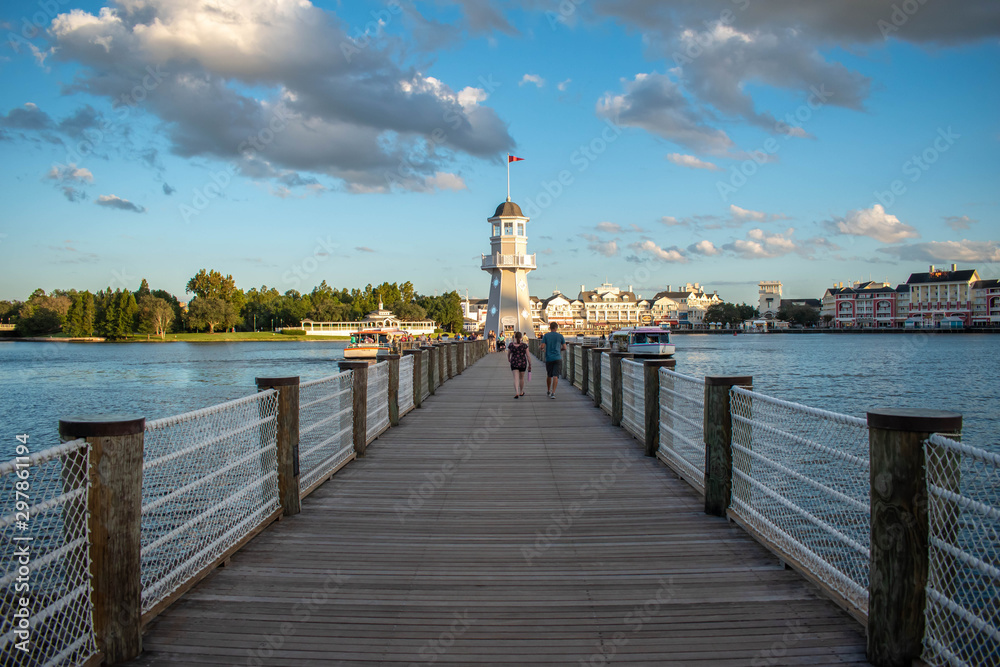 Orlando, Florida. October 11, 2019. People walking on pier on the way to lighthouse at Lake Buena Vista 89 - obrazy, fototapety, plakaty 