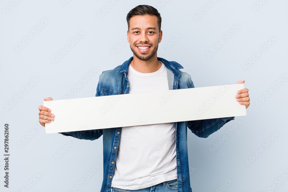 Young south-asian man holding a white placard. - obrazy, fototapety, plakaty 