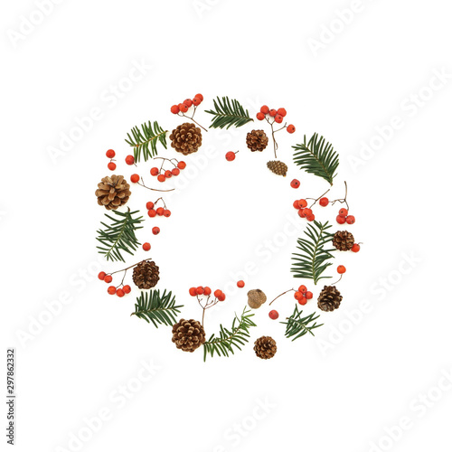 Natural composition with red ash berries beautiful pine acorn and evergreen branches . Holiday wreath imitation. Photo