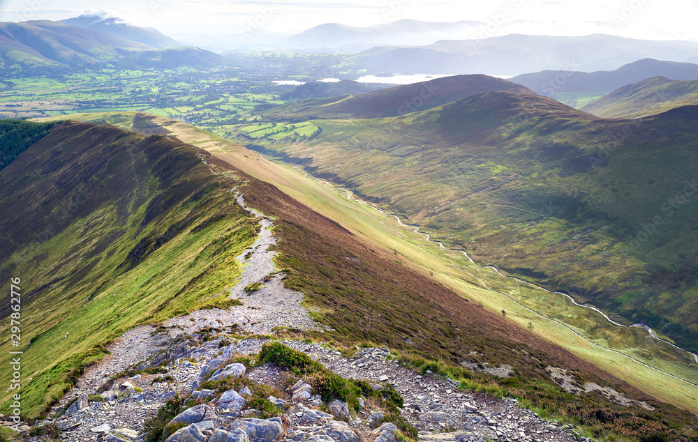 Views down Sleet How from Grisedale Pike with the small town of Braithwaite in the distance In the Lake District, England, UK.