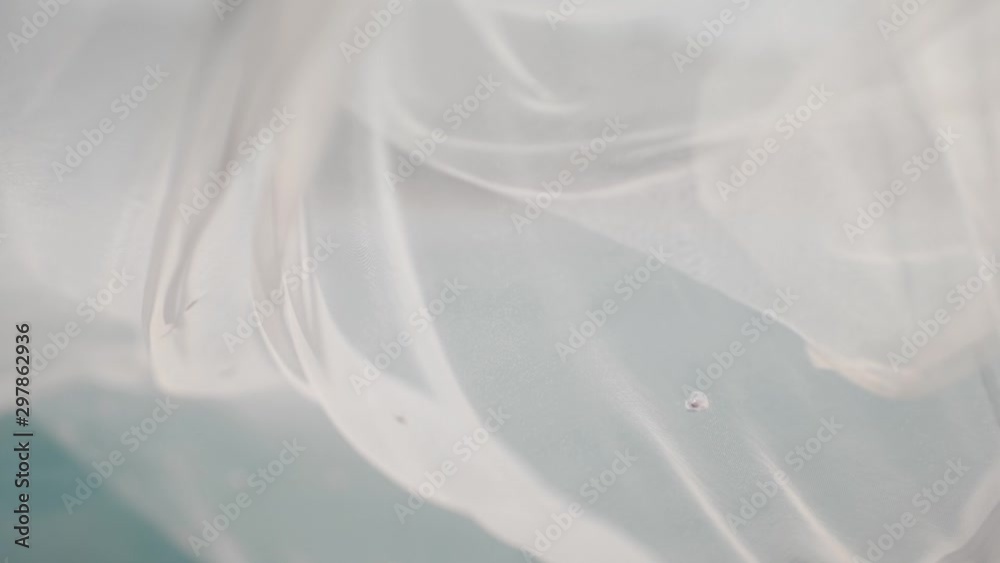 A white translucent veil blowing in the wind. A white translucent veil blowing in the wind.