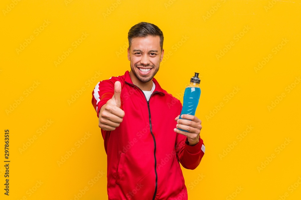 Young south-asian sport man holding an energy drink. Young south-asian sport man holding an energy drink.