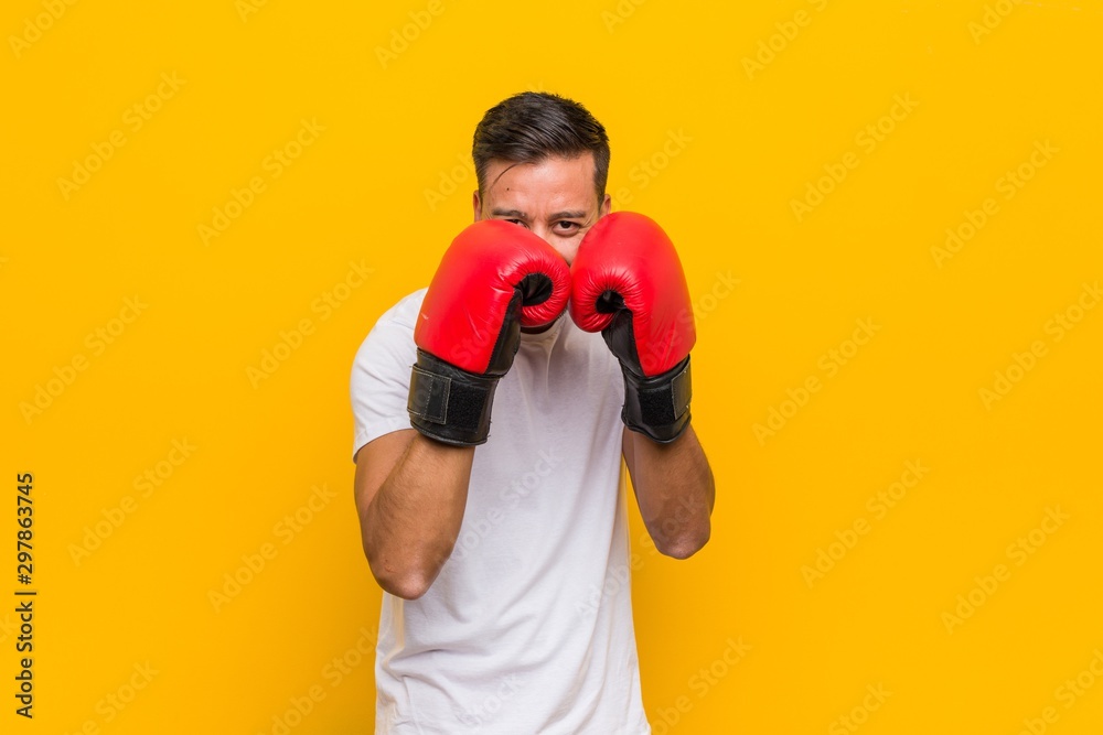 Young south-asian boxer man wearing red gloves.