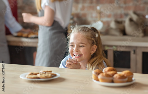 Adorable little girl looking with desire at sweets