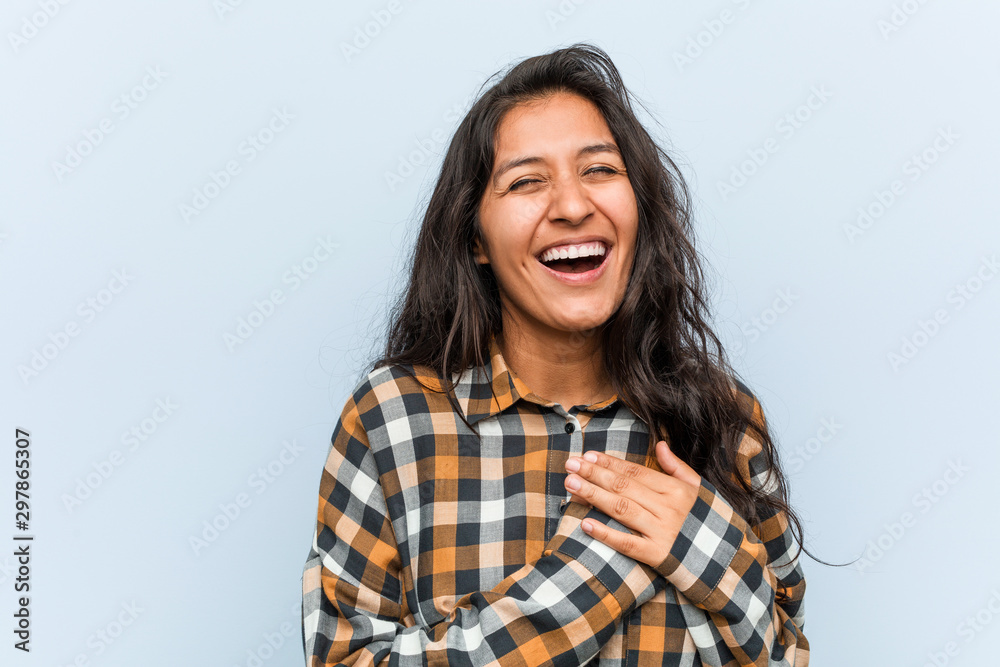 Young cool indian woman laughing keeping hands on heart, concept of happiness. Young cool indian woman laughing keeping hands on heart, concept of happiness.