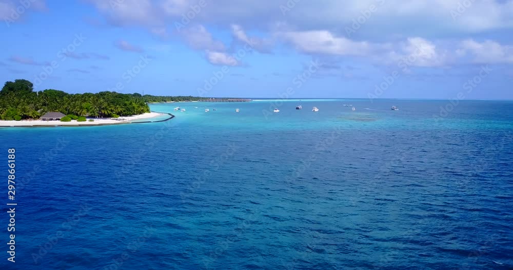 A number of boats are anchored offshore of a small tropical island in the Maldives A number of boats are anchored offshore of a small tropical island in the Maldives