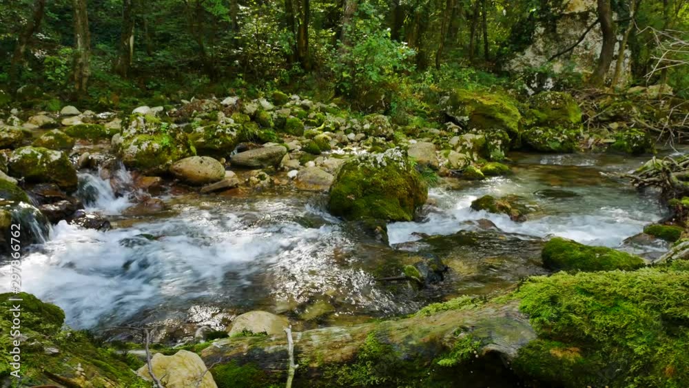 river stream flowing through the mossy rocks camera turning slowly upstream river stream flowing through the mossy rocks camera turning slowly upstream