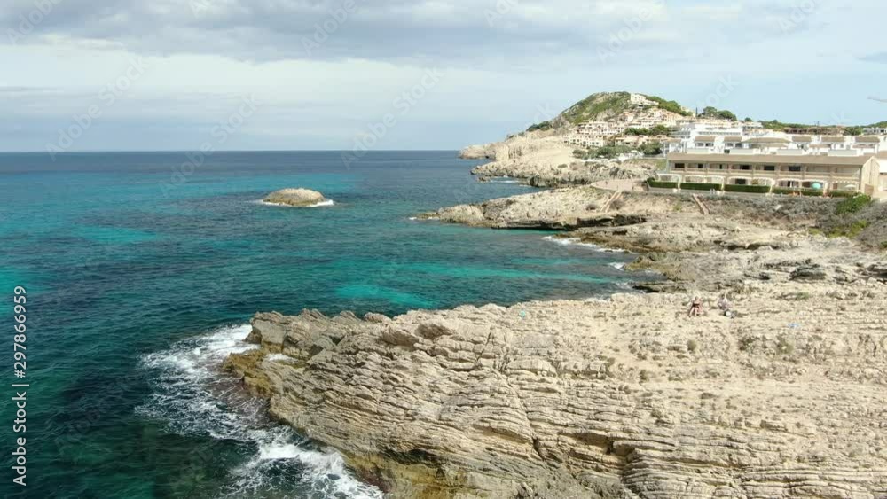 Moving aerial view of a beautiful sea and rocky beach with resorts and natural parks around. Moving aerial view of a beautiful sea and rocky beach with resorts and natural parks around.