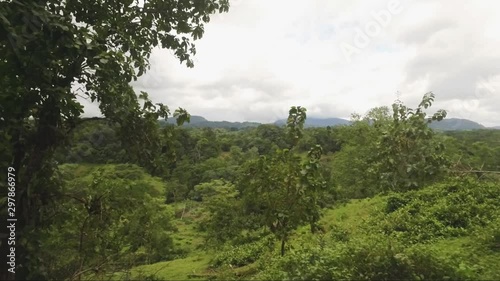 Costa Rican Rocky road with large old trees, lots of green, and a beautiful valley leading to the base of the San Isidro mountains in Costa Rica.  Located in Costa Rica pueblo called naranjito. photo