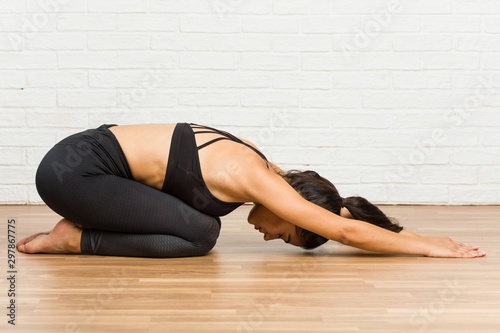 Young arab sporty woman practicing yoga on the floor