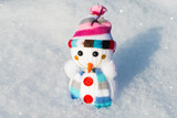 knitted toy snowman in the snow