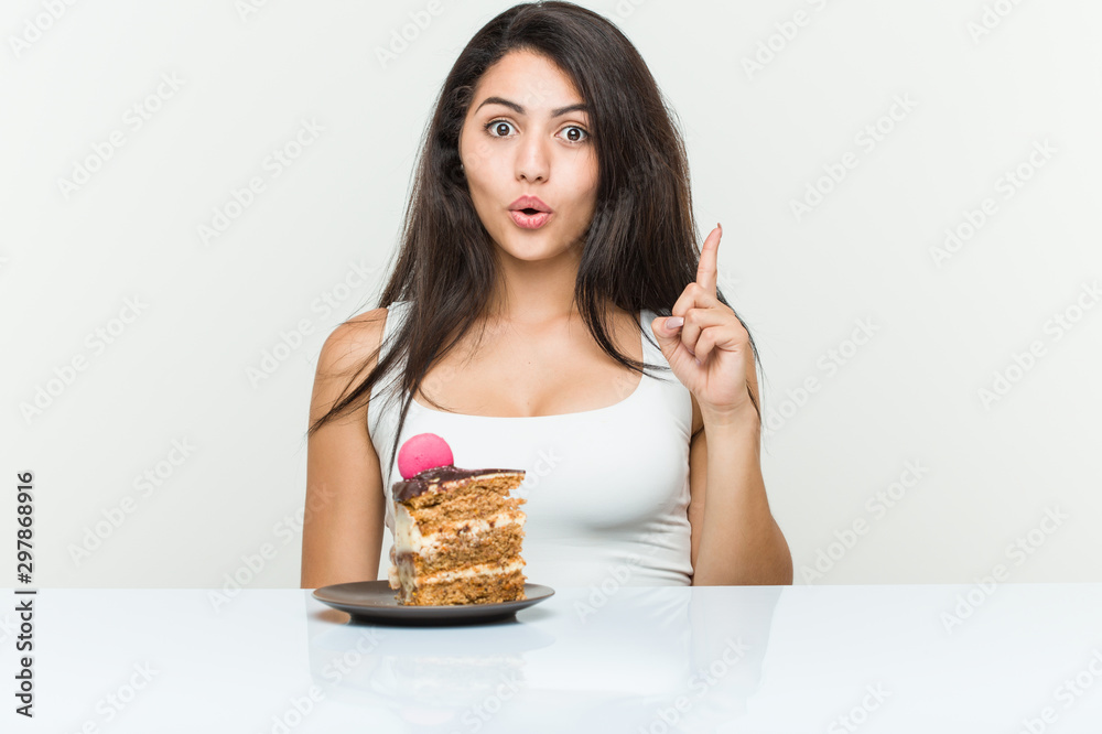 Young hispanic woman eating a cake having some great idea, concept of creativity. Young hispanic woman eating a cake having some great idea, concept of creativity.