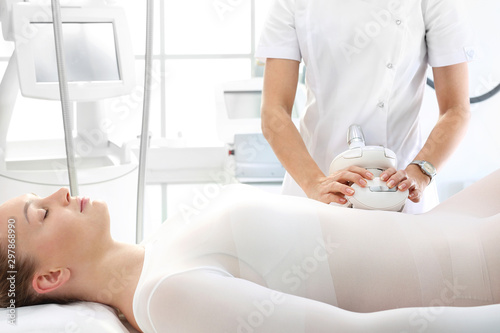 Flat stomach, a woman during a vacuum massage treatment using a professional device. Endermologie