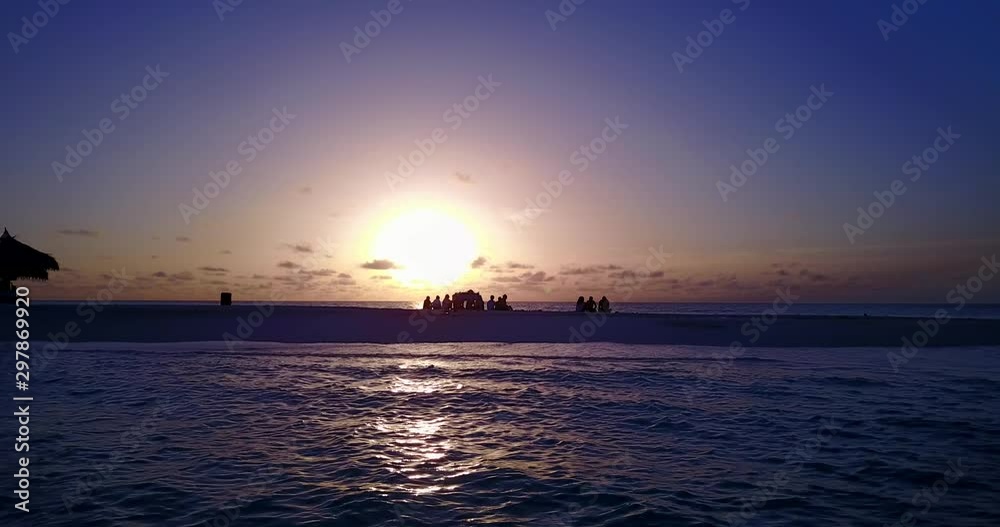 group of people sitting on the sandbank watching sunset and chatting. direct sunlight and silhouettes group of people sitting on the sandbank watching sunset and chatting. direct sunlight and silhouettes