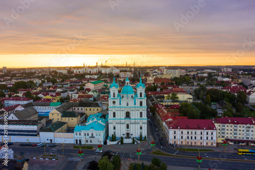 St. Francis Xavier Cathedral And Traffic In Mostowaja And Kirova Streets At Evening In Night Illuminations Lights. Sunset Sky. Grodno city in Belarus photo