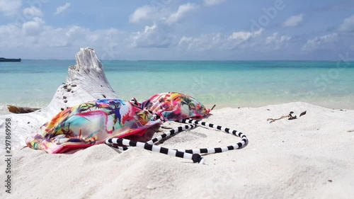 beachwear and perfect topical sandy beach background, bikini top on white sand on Pulau Kapas, Malaysia