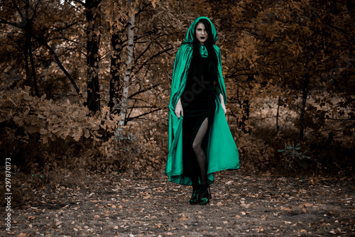 Woman in gothic style wear green carnival cloak, concept of simple Halloween ideas 