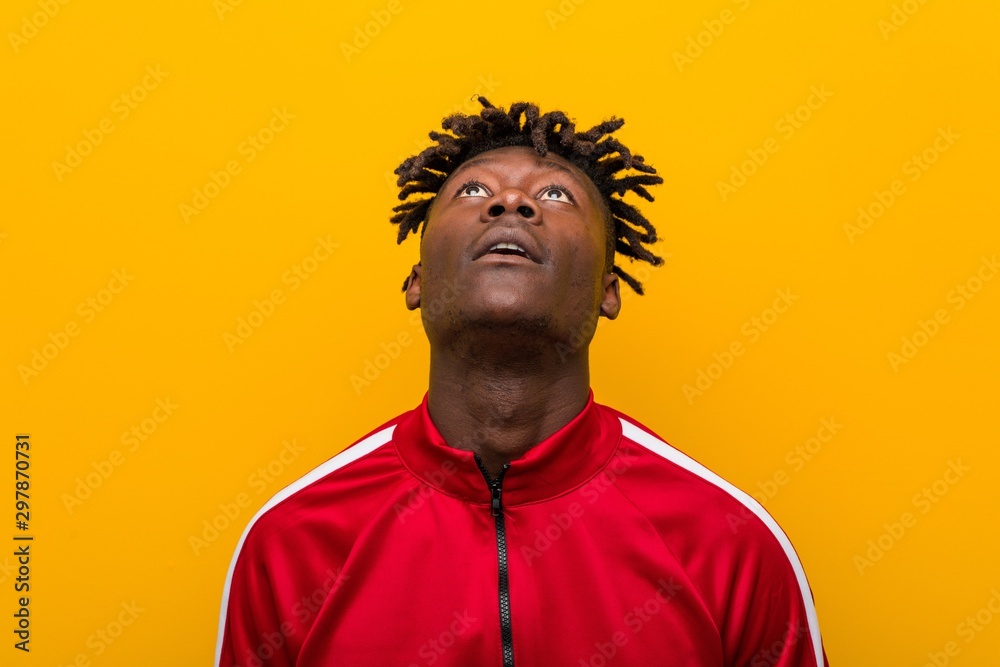 Close up of a young african sporty man standing against a yellow background Close up of a young african sporty man standing against a yellow background