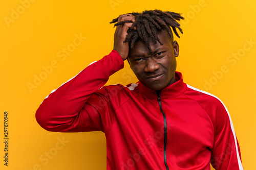 Young fitness black man tired and very sleepy keeping hand on his head.